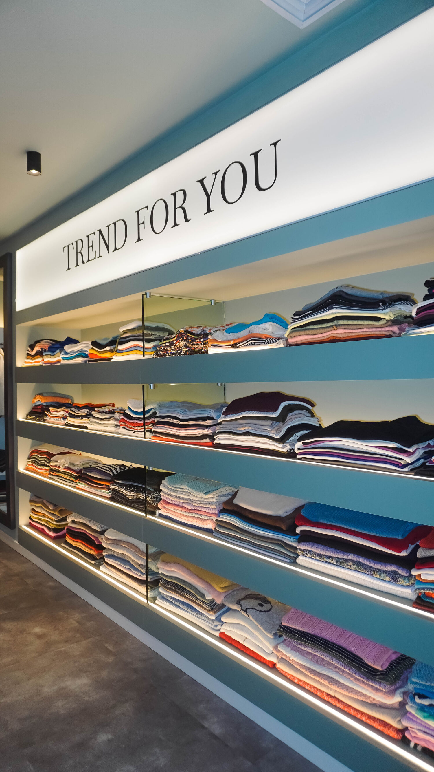 Showroom da Trend For You, com as prateleiras iluminadas sob o letreiro da marca